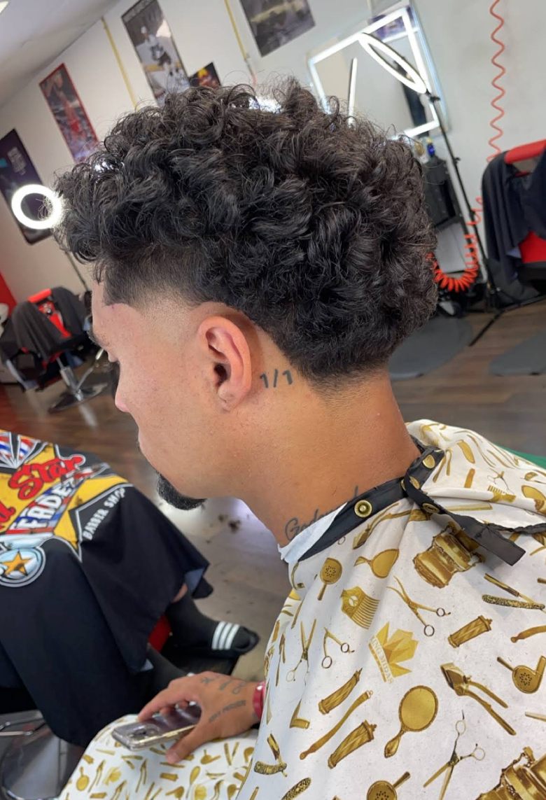 Curly hair on top with a blended low taper