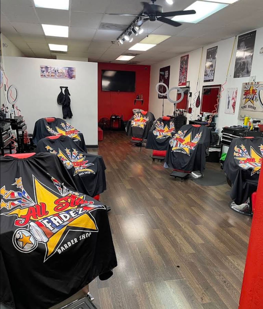 Inside All Star Fadez barber shop with branded capes on every chair